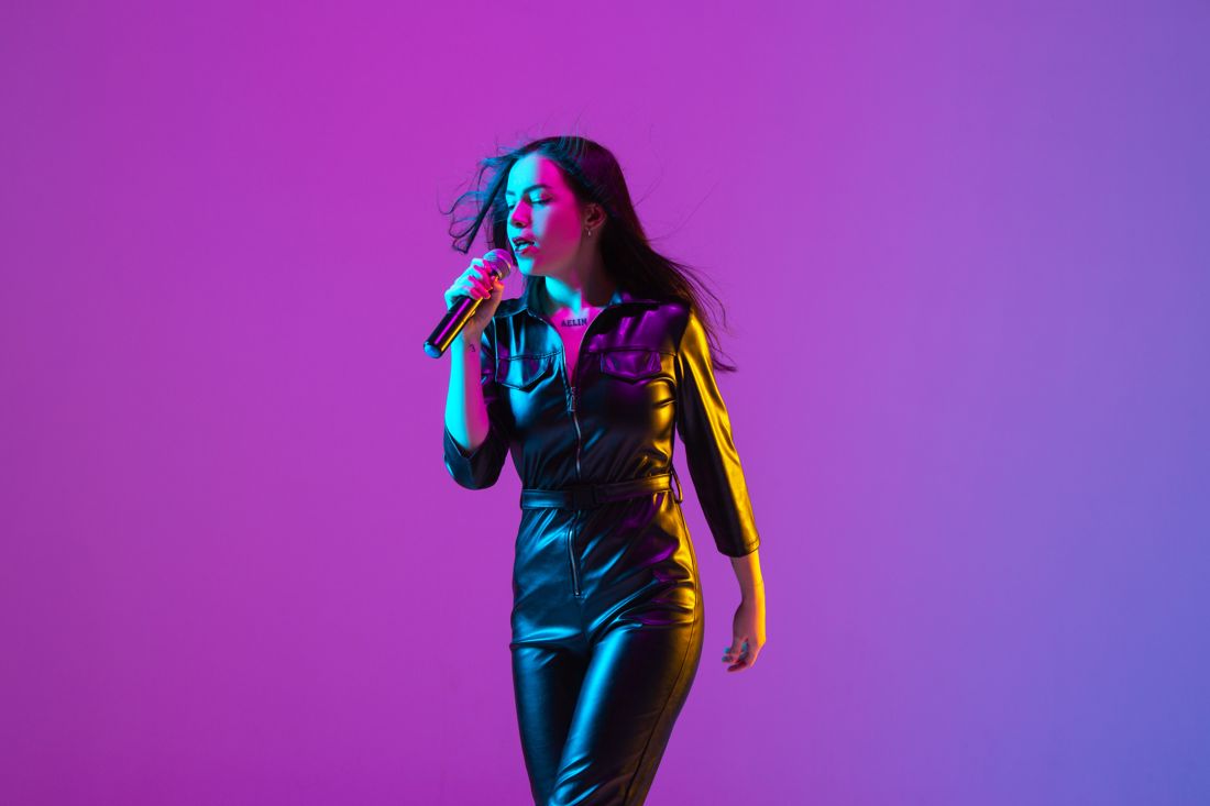 Singer with microphone under purple neon