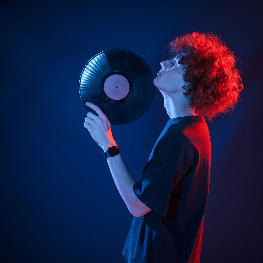 Holding a vinyl record in red and blue light