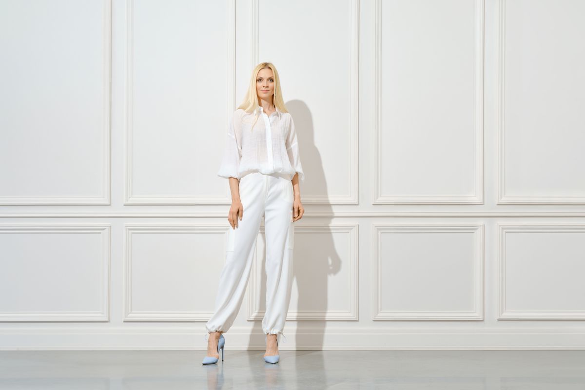 Model posing in a white outfit and heels
