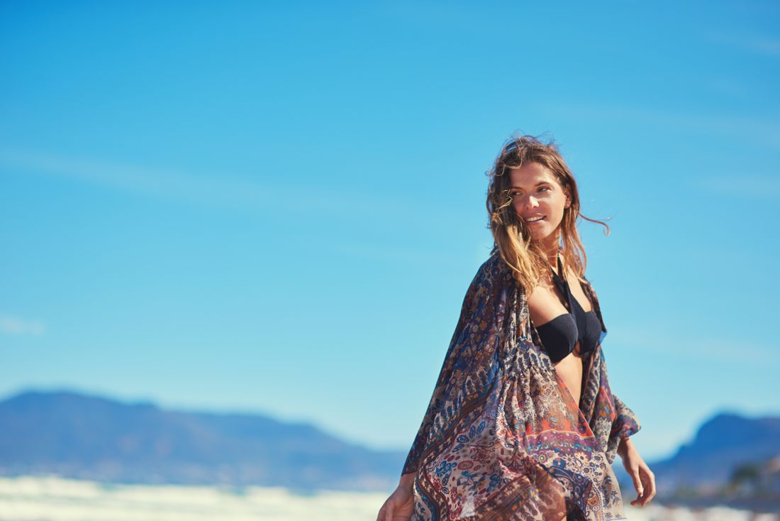 Model in a kimono over a bikini with desert mountains behind