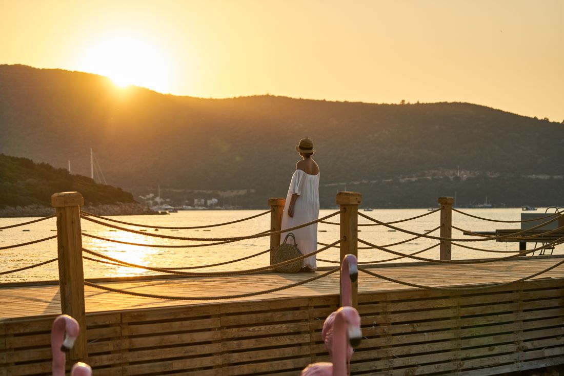 White dress on a pier at golden sunset