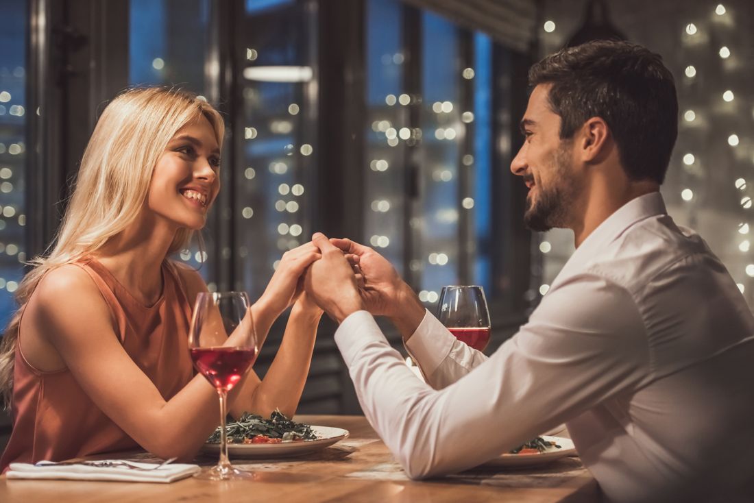 Couple holding hands at a restaurant table