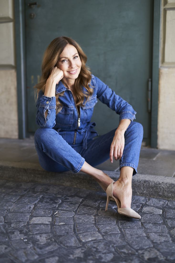 Model seated in a denim jumpsuit