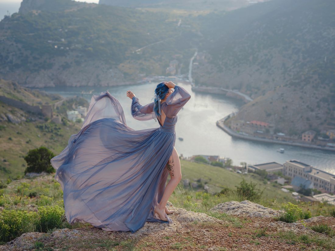 Blue flowing gown over a river valley