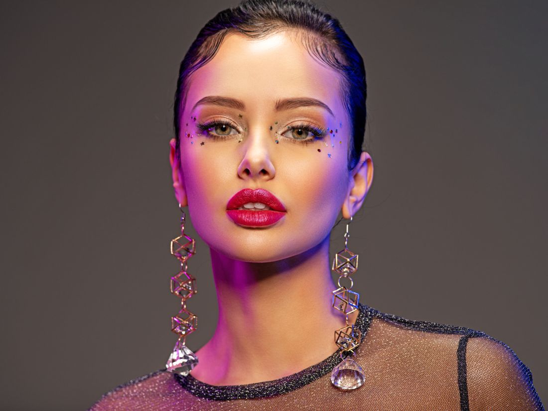 Glamour headshot with bold makeup and statement jewelry