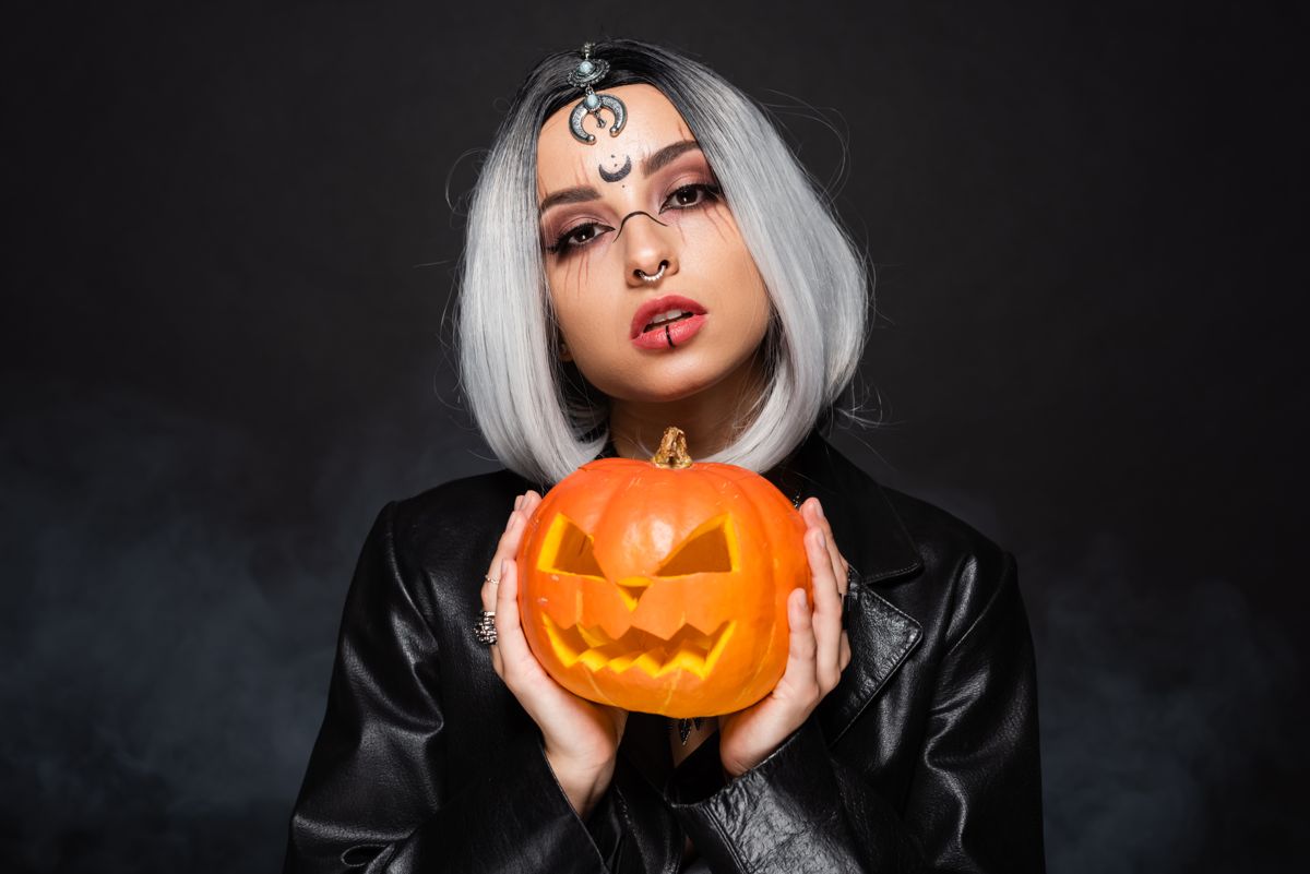 Portrait with a jack-o-lantern in moody light