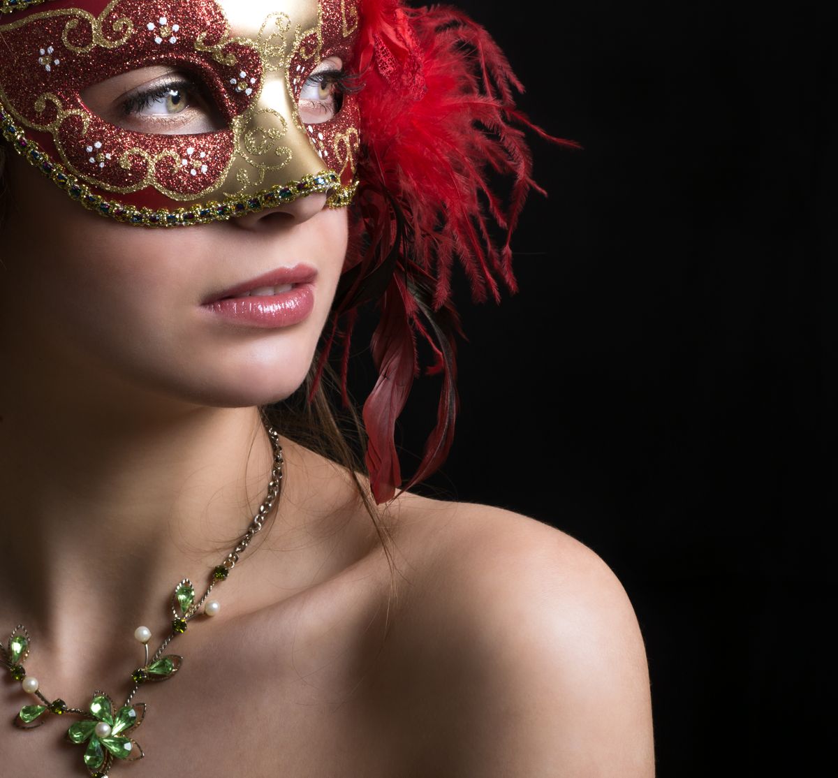 Model in a red mask with green necklace