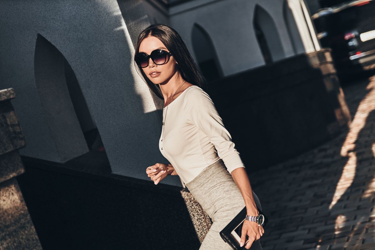 Woman in sunglasses with gold watch and leopard accents by marble arches