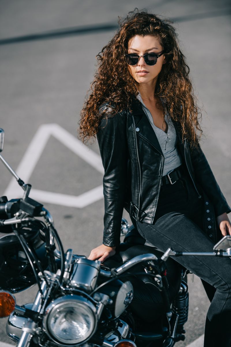 Model in a leather jacket seated on a motorcycle