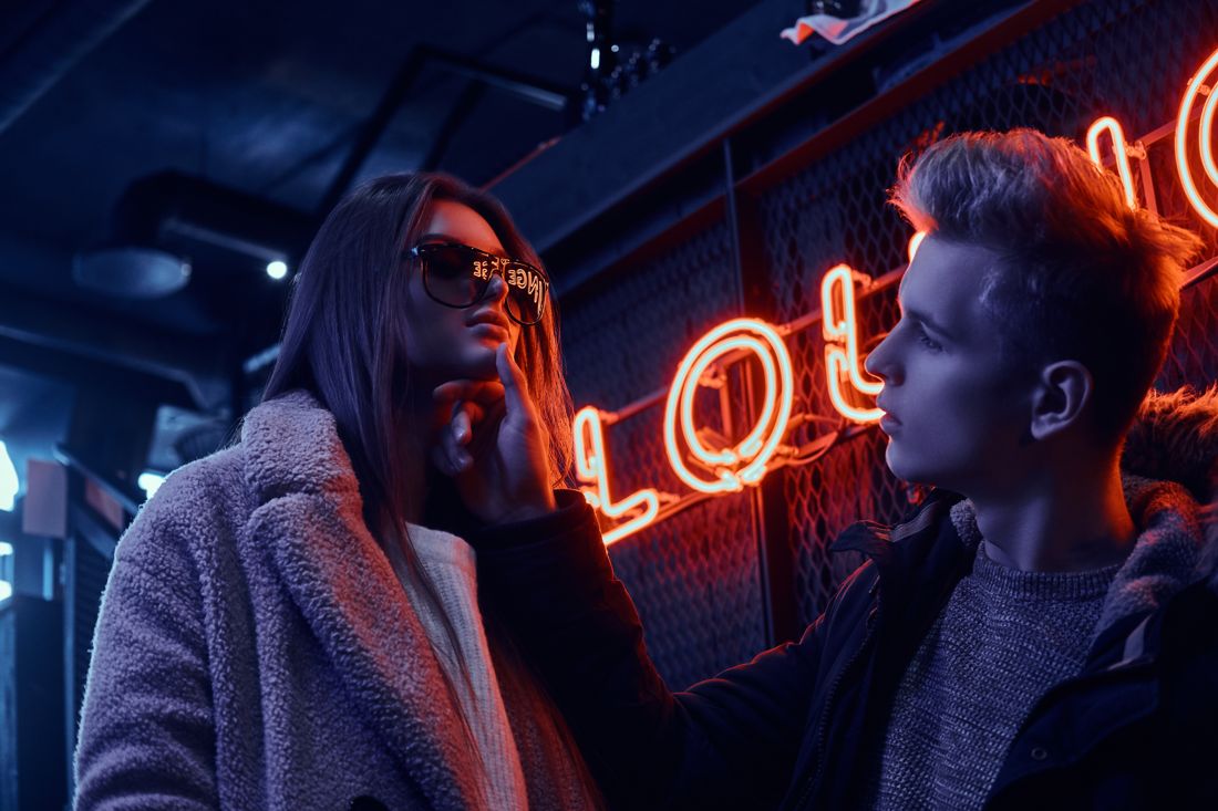 Couple under a neon lounge sign