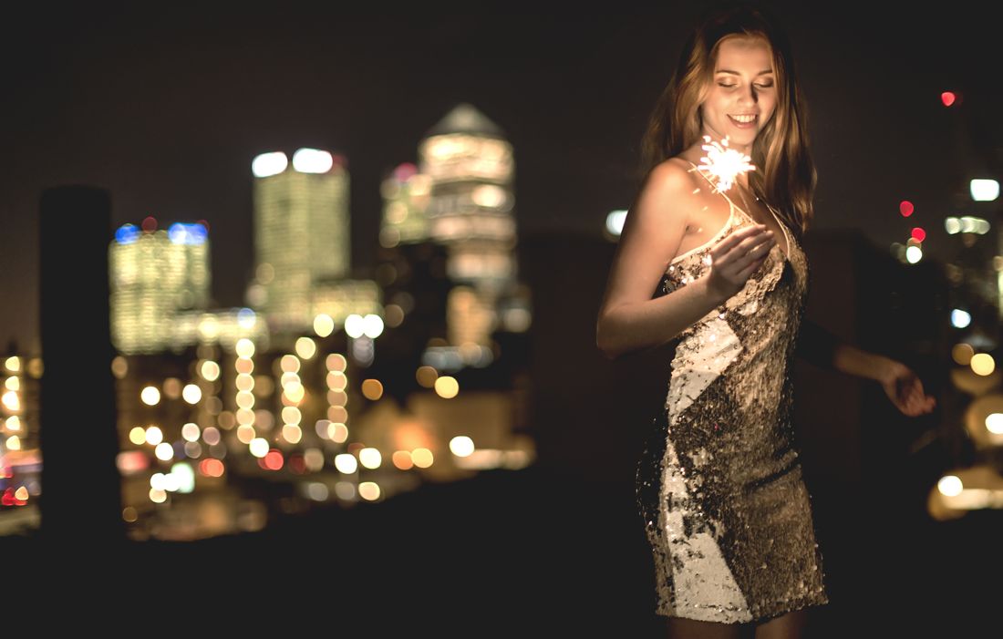 Sequin dress with a sparkler on a city rooftop at night