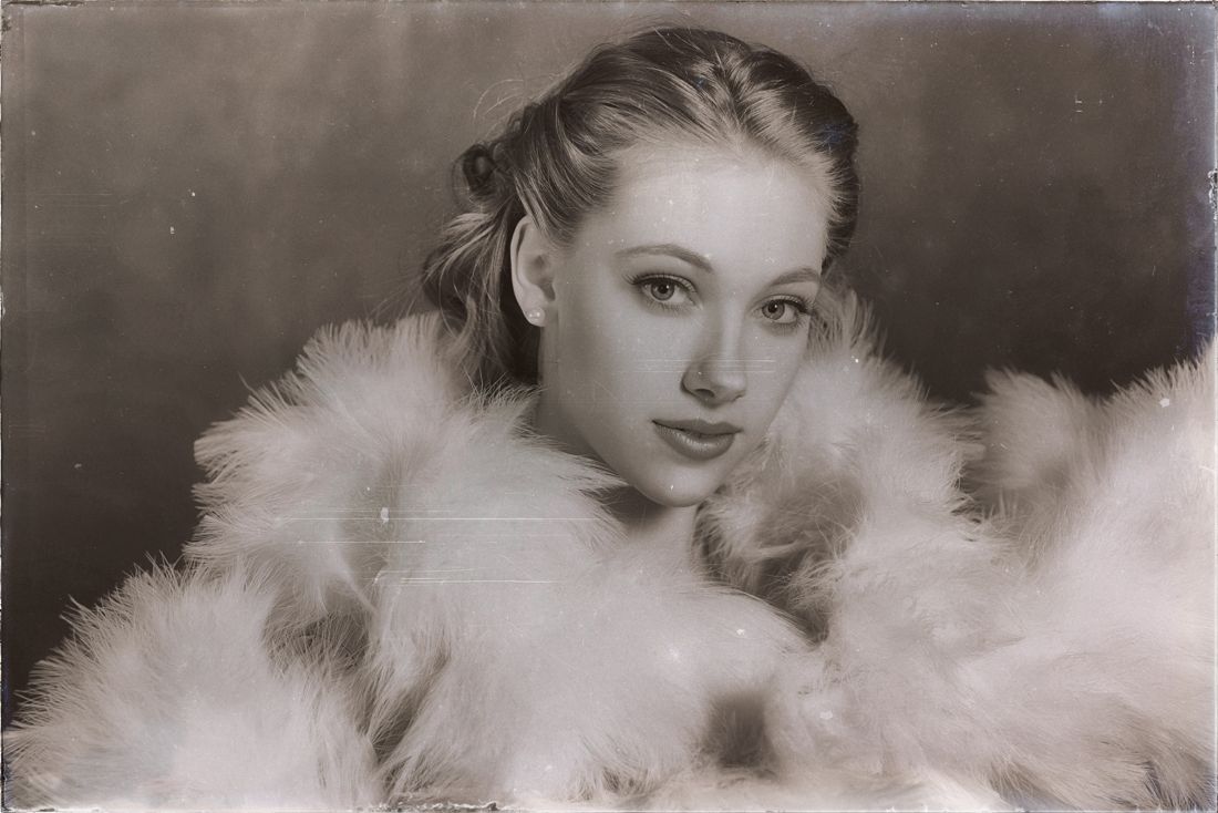 Model posing with a feathered shawl in the studio