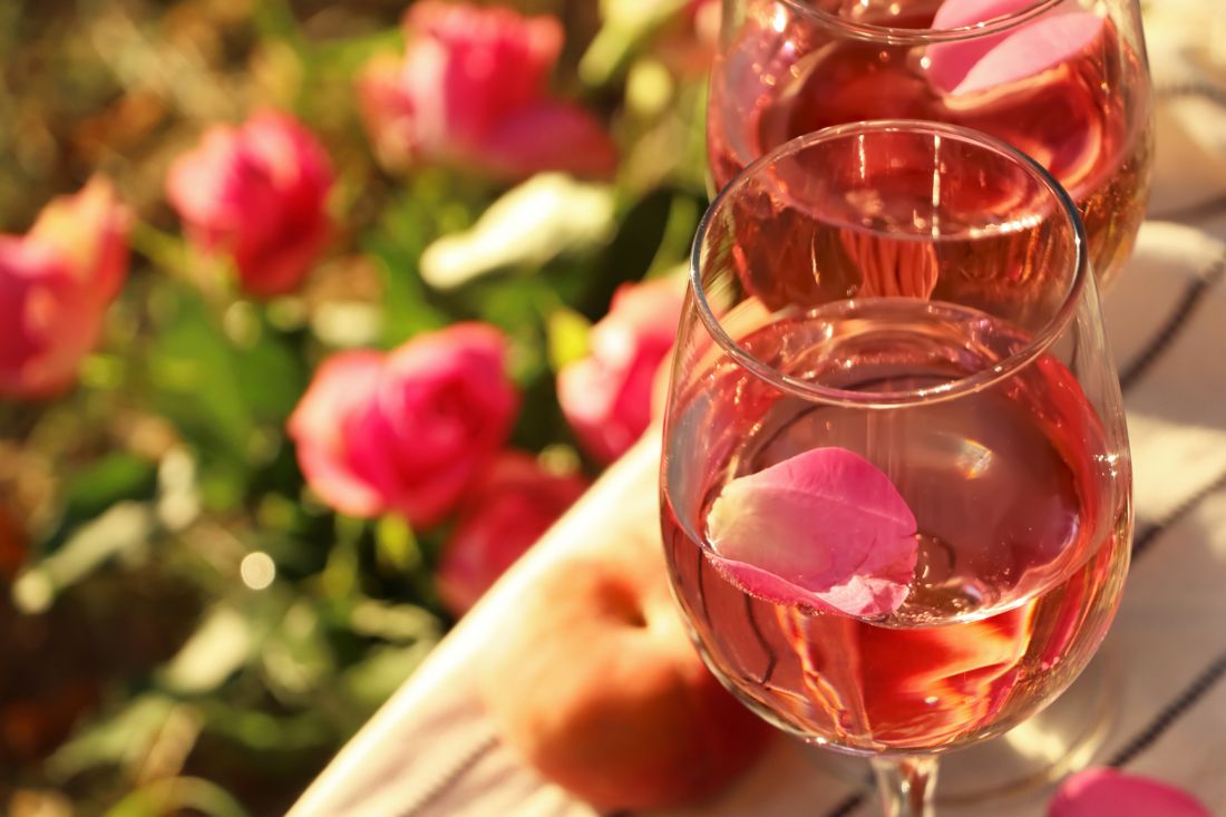 Rosé and flowers on a picnic blanket flat lay