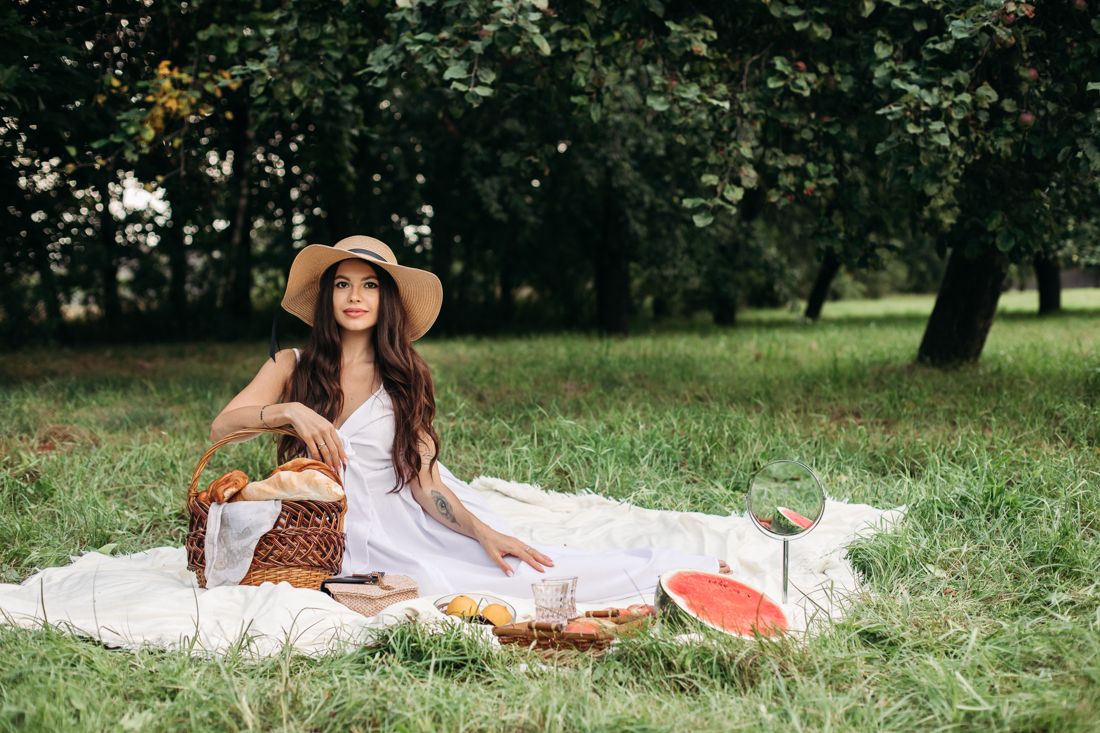 White dress and straw hat at a meadow picnic