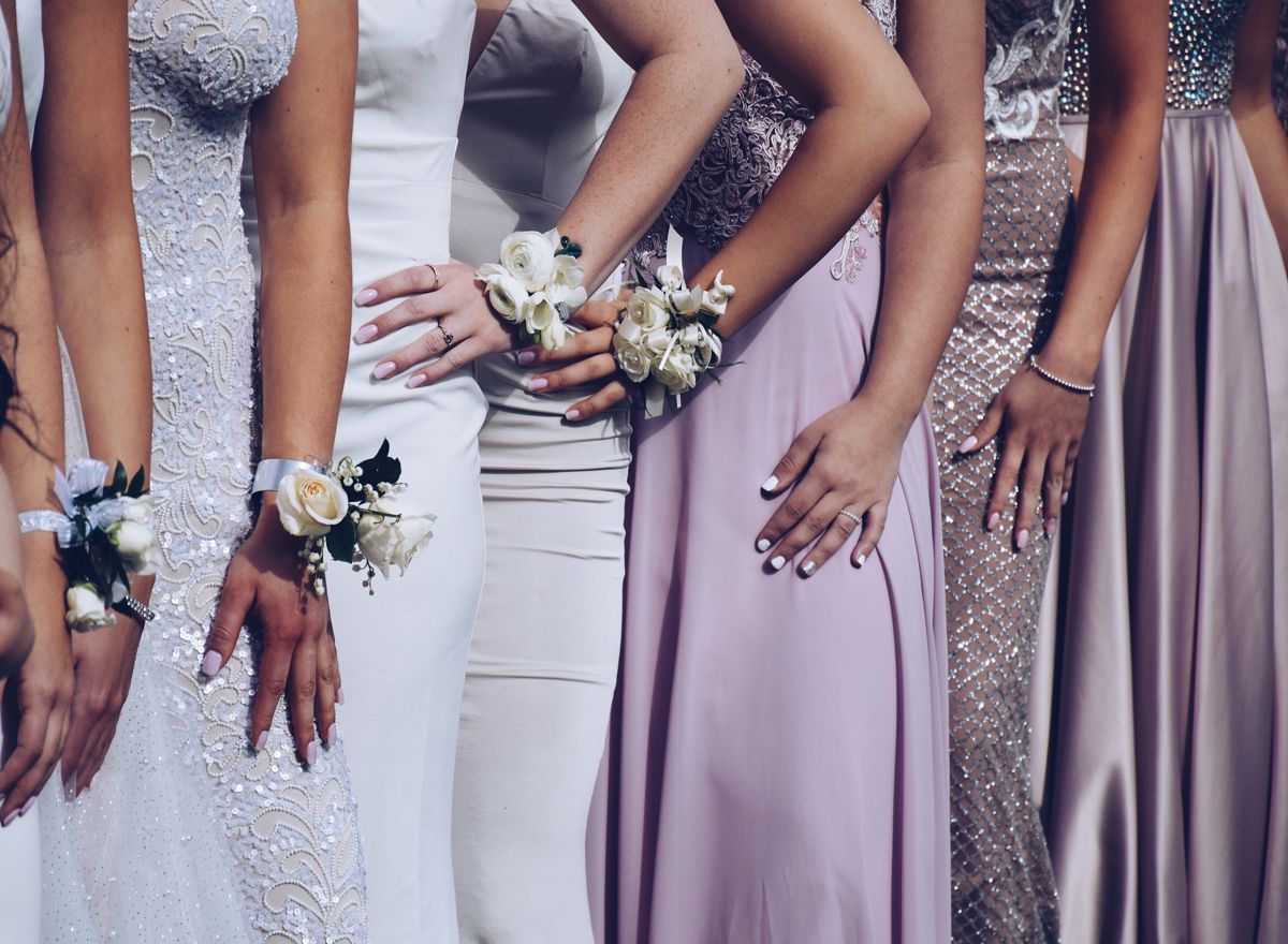 Row of formal gowns with wrist corsages