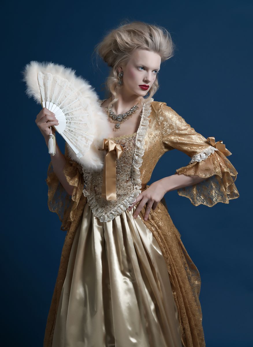 Baroque gold dress with a feather fan