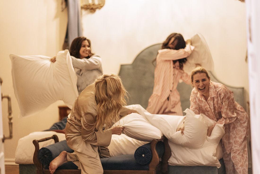 Friends mid pillow fight in pajamas
