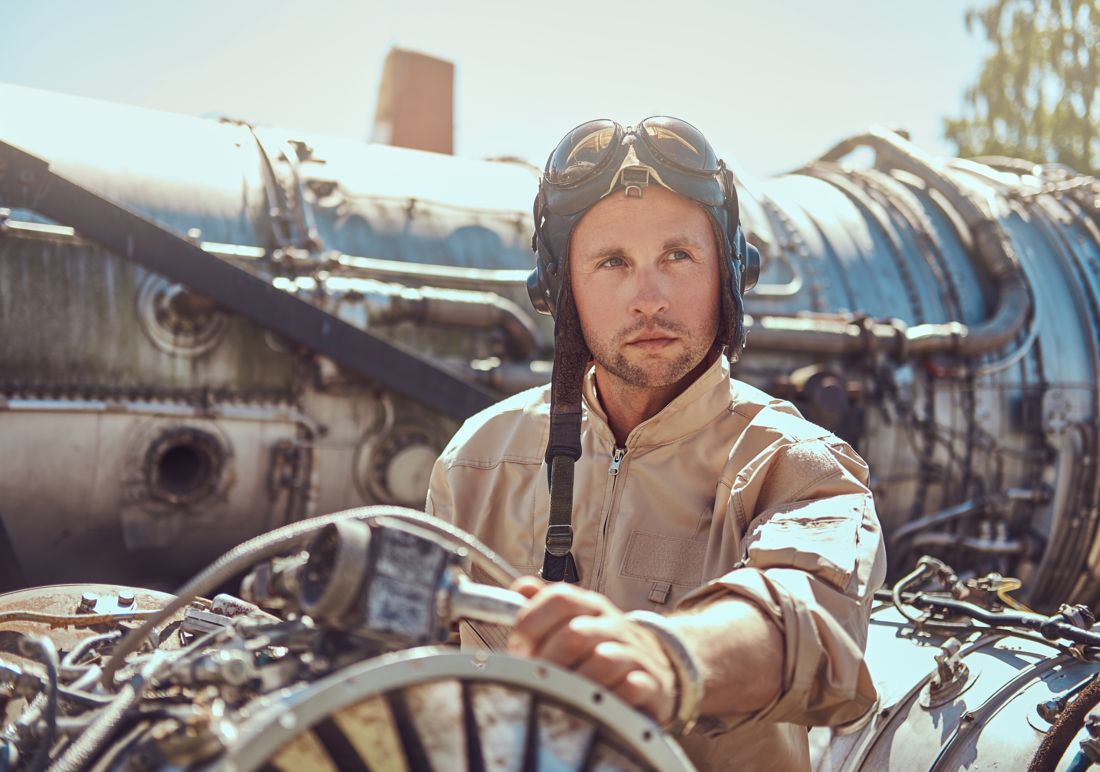 Aviator-goggled mechanic amid vintage aircraft machinery