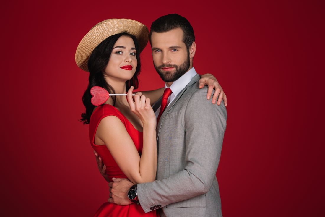 Couple in red dress and grey suit on red