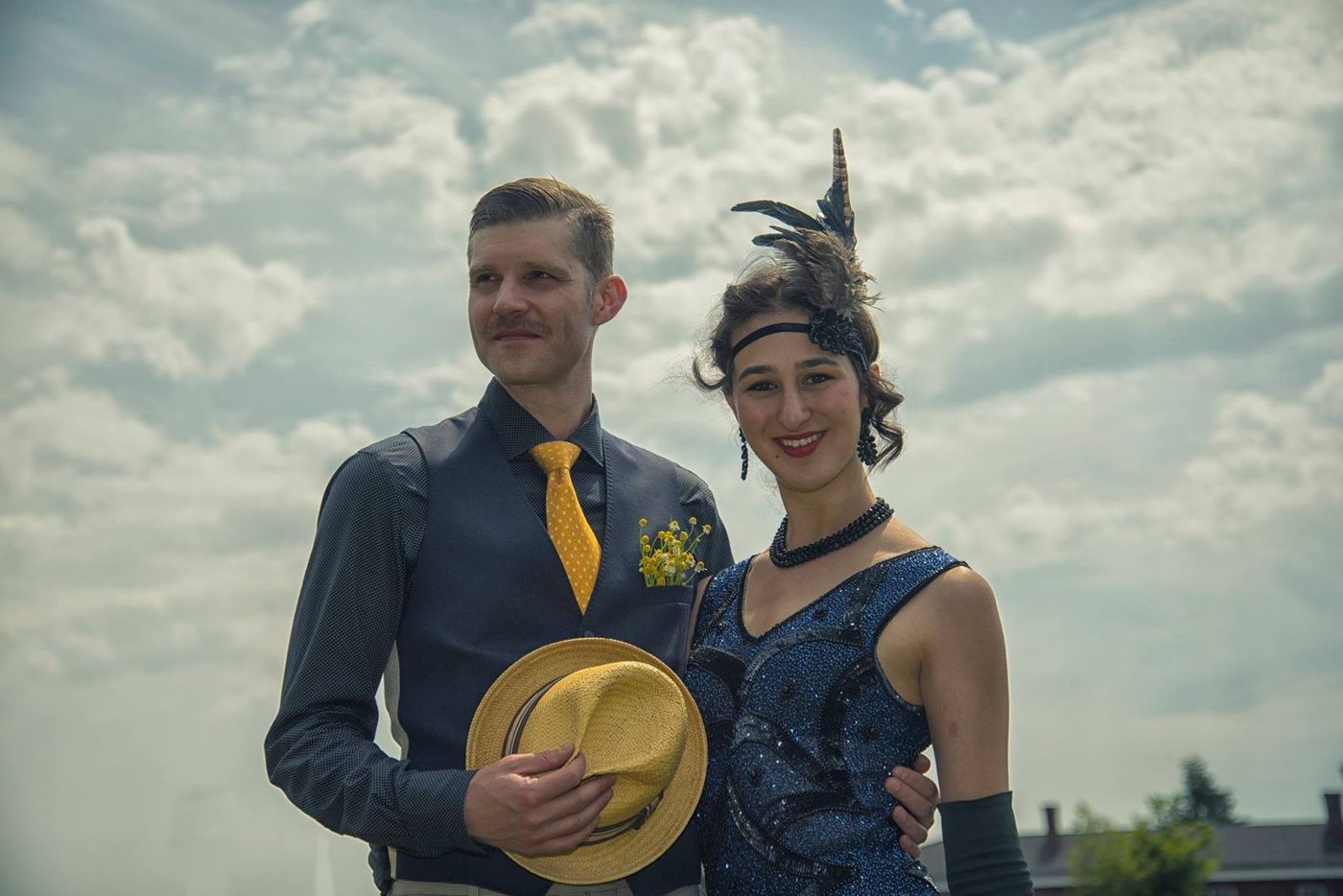 Couple in 1920s vintage dress against a summer sky