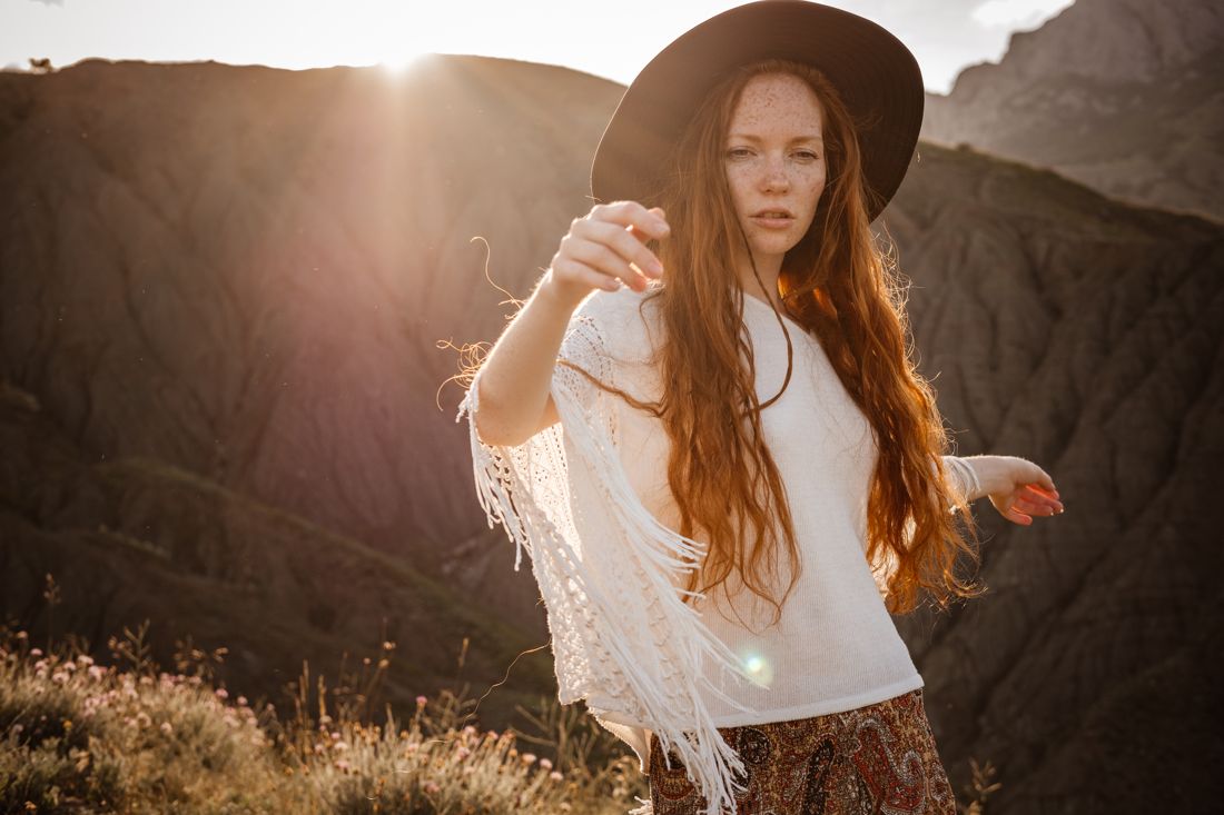 Backlit western look with hat and fringe shawl in a golden field